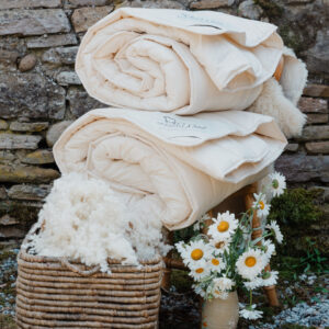 2 duvets with wool and flowers next to it, making it the perfect duvet for all seasons set