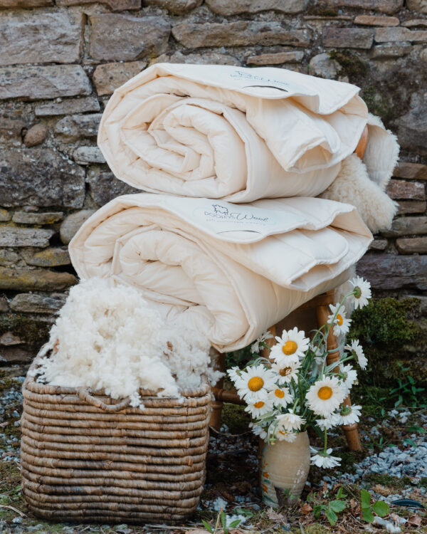 2 duvets with wool and flowers next to it, making it the perfect duvet for all seasons set
