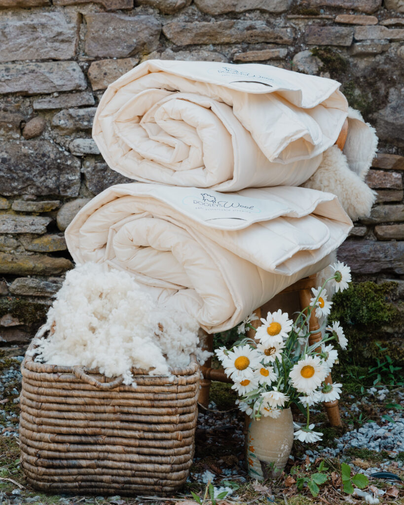 2 duvets with wool and flowers next to it, making it the perfect duvet for all seasons set